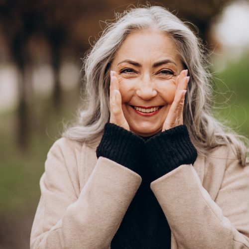 Elderly happy woman walking in park